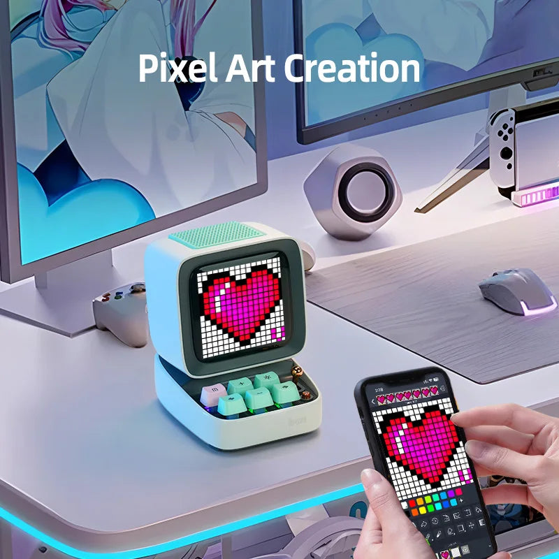 Pixel art creation setup with a small computer-like device and smartphone displaying pixel art on a desk.